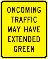 W25-2 - Oncoming Traffic May have Extended Green Sign