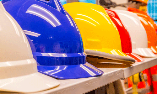 Shelf of different colored hard hats