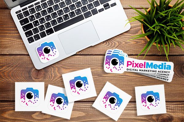 Custom logo stickers including square stickers with a camera graphic and die-cut with a camera graphic and text that reads Pixel Media.