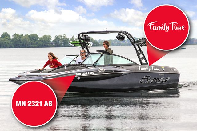 Black water skiing boat with a family on a lake with custom boat decals. One decal is the boat registration, the other is a decorative family related decal.