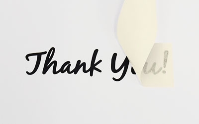 Custom Transfer Sticker on a wall that reads Thank You in cursive black lettering.