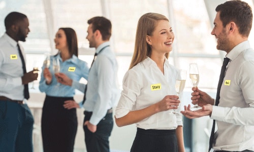Work mixer with business casual attire and men and women mingling holding glasses of white  wine