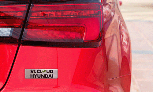 Custom domed decal on a red vehicle advertising for a car dealership.