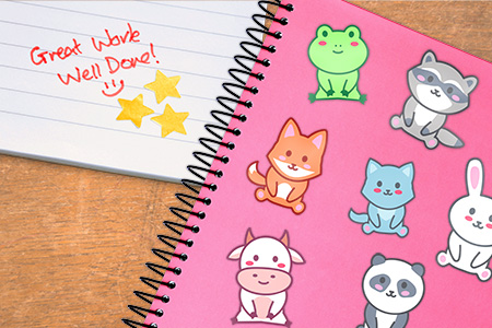 Pink notebook full of colorful stickers. Notebook paper with gold stars and red  pen text that reads Good Work, Well Done with a happy face.