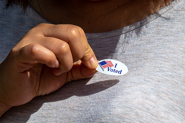 Hand holding a I Voted sticker