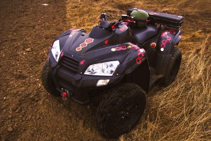 Black ATV with colorful custom ATV decals consisting of logos and graphics.