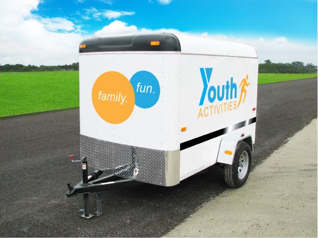 White trailer with custom trailer decals advertising for family fun and youth activities.