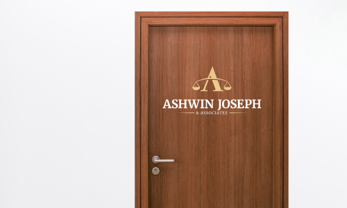 Mahogany wood door with Ashwin Joseph and Associates logo sticker.