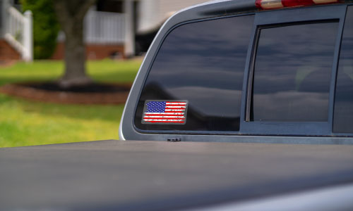 American Flag window sticker on the rear view window on a truck