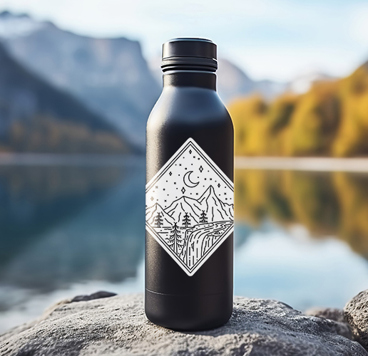 water bottle on a rock in front of a serene lake and mountains in the distant background