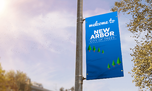 Blue double-sided pole banner hanging from light post. Banner text says Welcome to New Arbor City of Trees.